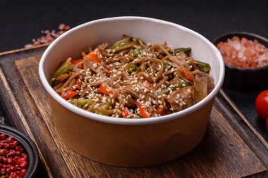 Karabuğday eriştesi, sebzeli, tuzlu ve baharatlı, koyu beton arka planda.