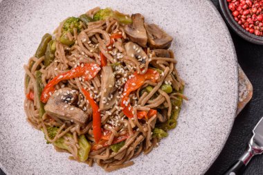 Karabuğday eriştesi, sebzeli, tuzlu ve baharatlı, koyu beton arka planda.