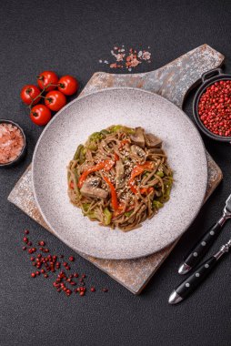 Karabuğday eriştesi, sebzeli, tuzlu ve baharatlı, koyu beton arka planda.