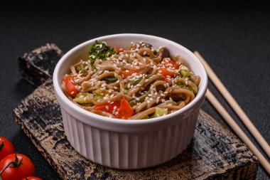 Karabuğday eriştesi, sebzeli, tuzlu ve baharatlı, koyu beton arka planda.