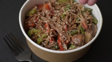 Karabuğday eriştesi, sebzeli, tuzlu ve baharatlı, koyu beton arka planda.