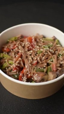 Karabuğday eriştesi, sebzeli, tuzlu ve baharatlı, koyu beton arka planda.