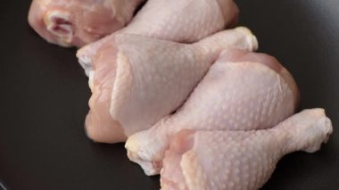 Çiğ tavuk budu, tuzlu, baharatlı ve ızgara için hazırlanmış otlar.