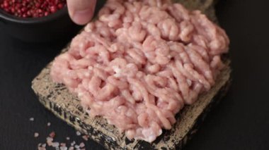 Koyu beton arka planda tuzlu, baharatlı ve otlu çiğ tavuk.