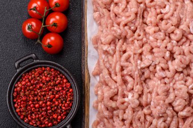 Koyu beton arka planda tuzlu, baharatlı ve otlu çiğ tavuk.