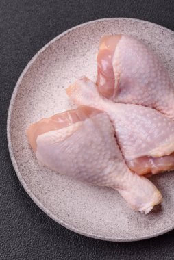 Çiğ tavuk budu, tuzlu, baharatlı ve ızgara için hazırlanmış otlar.