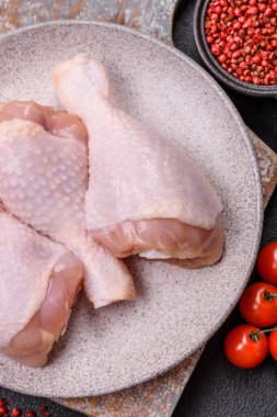 Çiğ tavuk budu, tuzlu, baharatlı ve ızgara için hazırlanmış otlar.