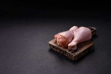 Çiğ tavuk budu, tuzlu, baharatlı ve ızgara için hazırlanmış otlar.