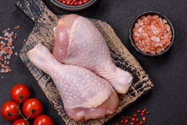 Çiğ tavuk budu, tuzlu, baharatlı ve ızgara için hazırlanmış otlar.