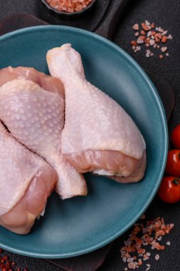 Çiğ tavuk budu, tuzlu, baharatlı ve ızgara için hazırlanmış otlar.