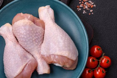 Çiğ tavuk budu, tuzlu, baharatlı ve ızgara için hazırlanmış otlar.