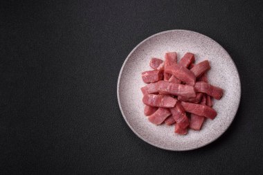 Koyu beton zeminde tuz, baharat ve otlarla dilimlenmiş sulu sığır eti.