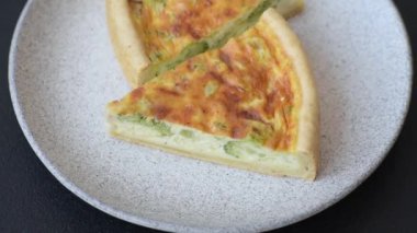 Brokoli, tavuk ya da somon peynirli lezzetli kiş. Koyu beton bir arka planda tuz ve baharatla.