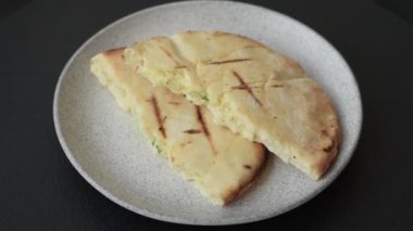 Peynirli, otlu, tuzlu ve baharatlı, ızgarada pişirilmiş yuvarlak ekmek ya da pide