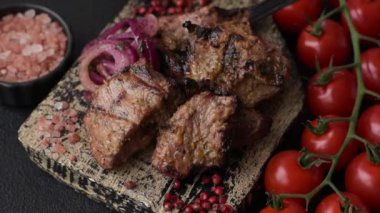 Dilimlenmiş et parçaları, tuz, baharat ve otlarla marine edilmiş ve ızgara.