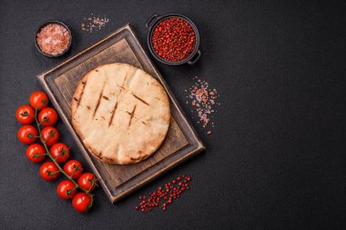 Peynirli, otlu, tuzlu ve baharatlı, ızgarada pişirilmiş yuvarlak ekmek ya da pide