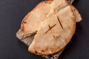 Peynirli, otlu, tuzlu ve baharatlı, ızgarada pişirilmiş yuvarlak ekmek ya da pide