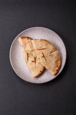 Peynirli, otlu, tuzlu ve baharatlı, ızgarada pişirilmiş yuvarlak ekmek ya da pide