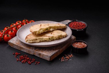 Peynirli, otlu, tuzlu ve baharatlı, ızgarada pişirilmiş yuvarlak ekmek ya da pide