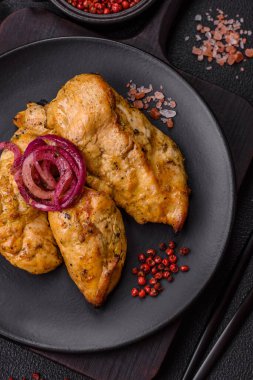 Tuz, baharat ve otlarla marine edilmiş tavuk fileto parçaları ve ızgara.