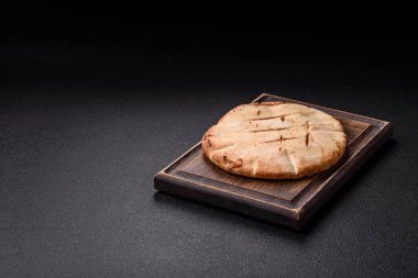 Peynirli, otlu, tuzlu ve baharatlı, ızgarada pişirilmiş yuvarlak ekmek ya da pide