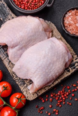 Çiğ tavuk butları, tuzlu, baharatlı ve ızgara için hazırlanmış otlar.