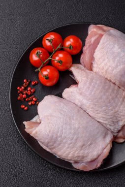 Çiğ tavuk butları, tuzlu, baharatlı ve ızgara için hazırlanmış otlar.