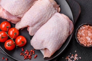 Çiğ tavuk butları, tuzlu, baharatlı ve ızgara için hazırlanmış otlar.