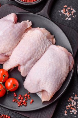 Çiğ tavuk butları, tuzlu, baharatlı ve ızgara için hazırlanmış otlar.