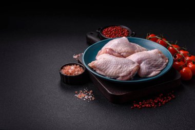 Çiğ tavuk butları, tuzlu, baharatlı ve ızgara için hazırlanmış otlar.