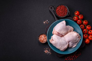 Çiğ tavuk butları, tuzlu, baharatlı ve ızgara için hazırlanmış otlar.