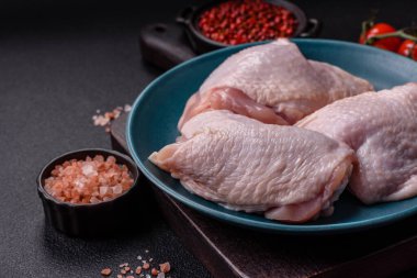 Çiğ tavuk butları, tuzlu, baharatlı ve ızgara için hazırlanmış otlar.