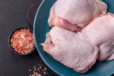 Çiğ tavuk butları, tuzlu, baharatlı ve ızgara için hazırlanmış otlar.