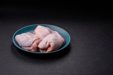 Çiğ tavuk butları, tuzlu, baharatlı ve ızgara için hazırlanmış otlar.