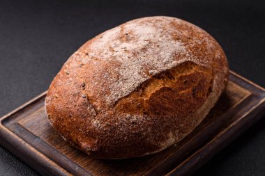 Koyu beton arka planda sandviçler için tohumlu ve tahıllı kahverengi ekmek.