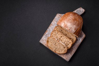 Koyu beton arka planda sandviçler için tohumlu ve tahıllı kahverengi ekmek.