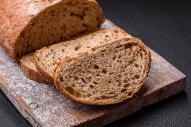 Koyu beton arka planda sandviçler için tohumlu ve tahıllı kahverengi ekmek.