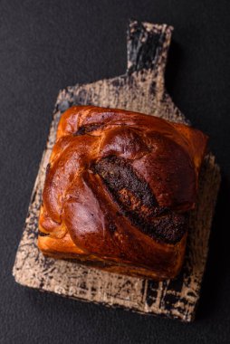 Aile ziyafeti ve çay partisi için koyu beton arka planda haşhaşlı kek.