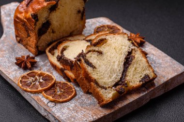 Aile ziyafeti ve çay partisi için koyu beton arka planda haşhaşlı kek.