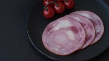 Koyu beton bir arka planda tuz ve baharatla dilimlenmiş jambon.