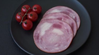 Koyu beton bir arka planda tuz ve baharatla dilimlenmiş jambon.