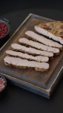 Koyu beton bir arka planda ızgara biftek veya tuzlu, baharatlı ve otlu domuz eti.