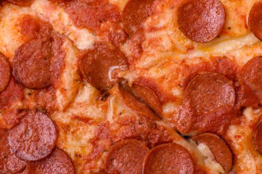Sosisli biberli pizza, mozzarella peyniri, domates, tuz ve baharatlar koyu beton arka planda.