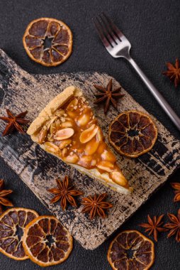 Lezzetli taze cheesecake keki ya da koyu beton arka planda seramik tabakta kremalı ve fındıklı snickers.