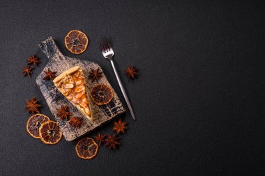 Lezzetli taze cheesecake keki ya da koyu beton arka planda seramik tabakta kremalı ve fındıklı snickers.