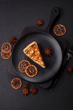 Lezzetli taze cheesecake keki ya da koyu beton arka planda seramik tabakta kremalı ve fındıklı snickers.