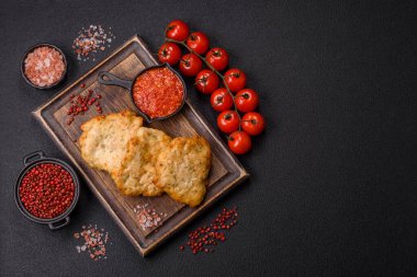 Lezzetli kızarmış domuz ya da koyu beton arka planda tuz ve baharatla ekilmiş tavuk pirzolası.