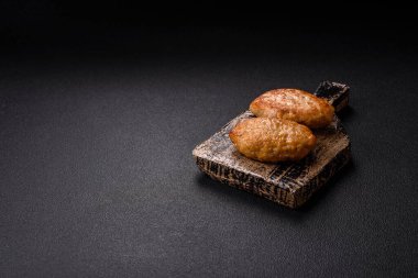 Lezzetli taze kıymalı balık pirzolası. Esmer arka planda baharatlar ve otlarla birlikte.