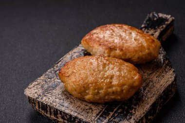 Lezzetli taze kıymalı balık pirzolası. Esmer arka planda baharatlar ve otlarla birlikte.