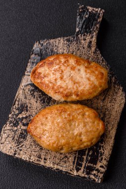 Lezzetli taze kıymalı balık pirzolası. Esmer arka planda baharatlar ve otlarla birlikte.